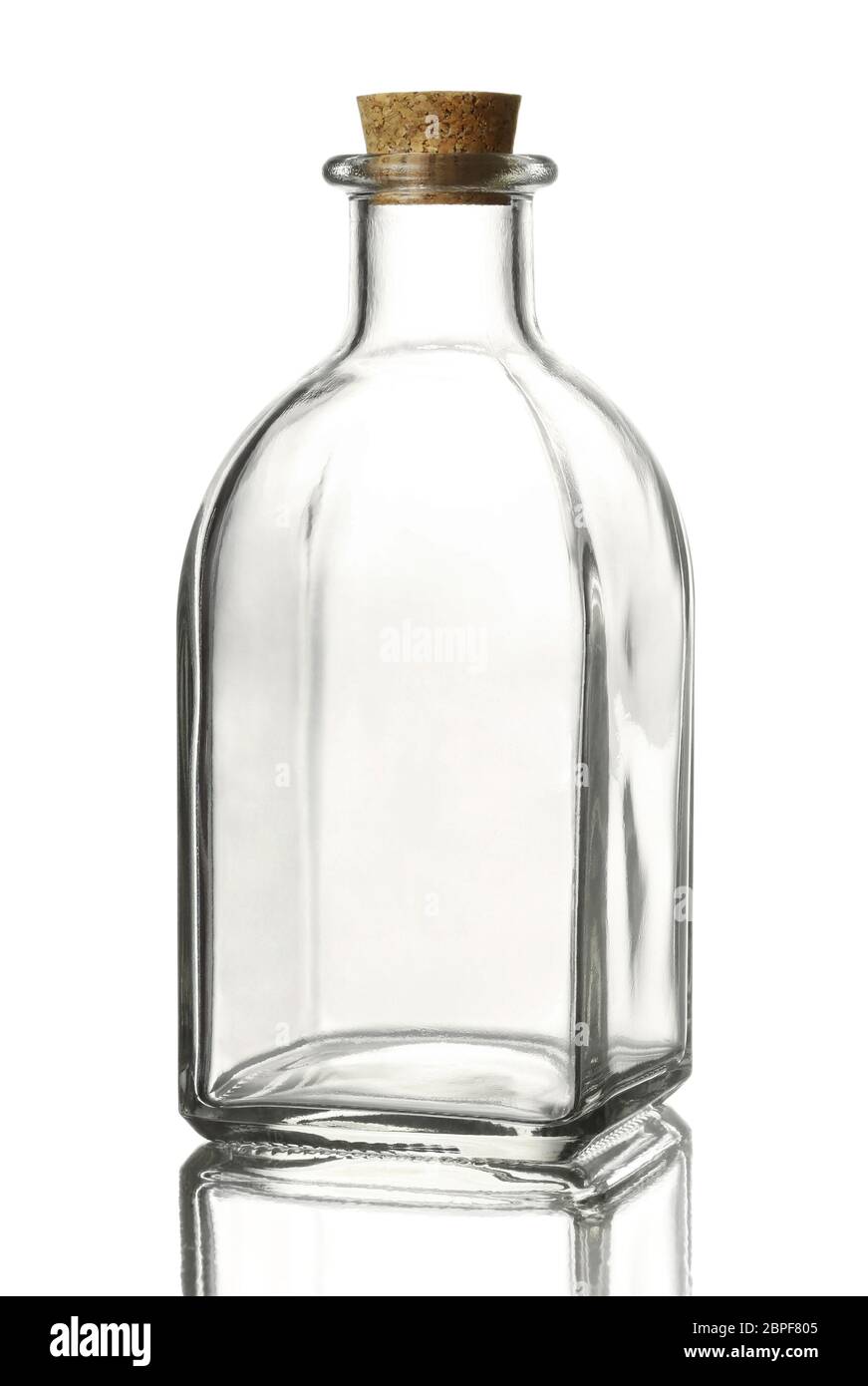Flacone di vetro trasparente vuoto di forma quadrata con tappo in sughero su una superficie riflettente, isolato su fondo bianco. Foto Stock