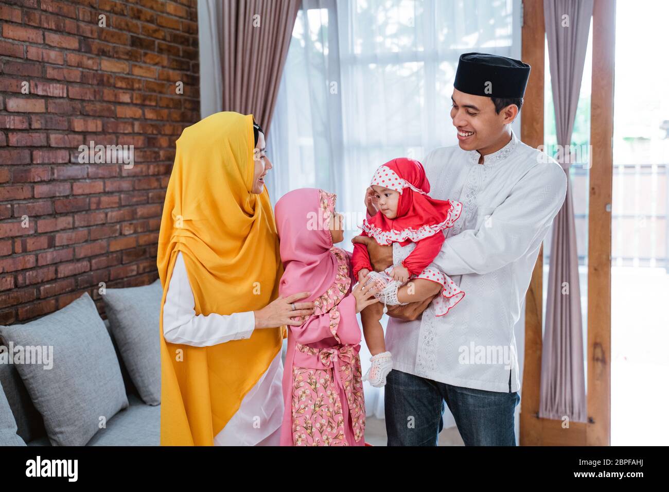 Famiglia asiatica Eid Mubarak. famiglia asiatica con figlia e bambino a casa Foto Stock