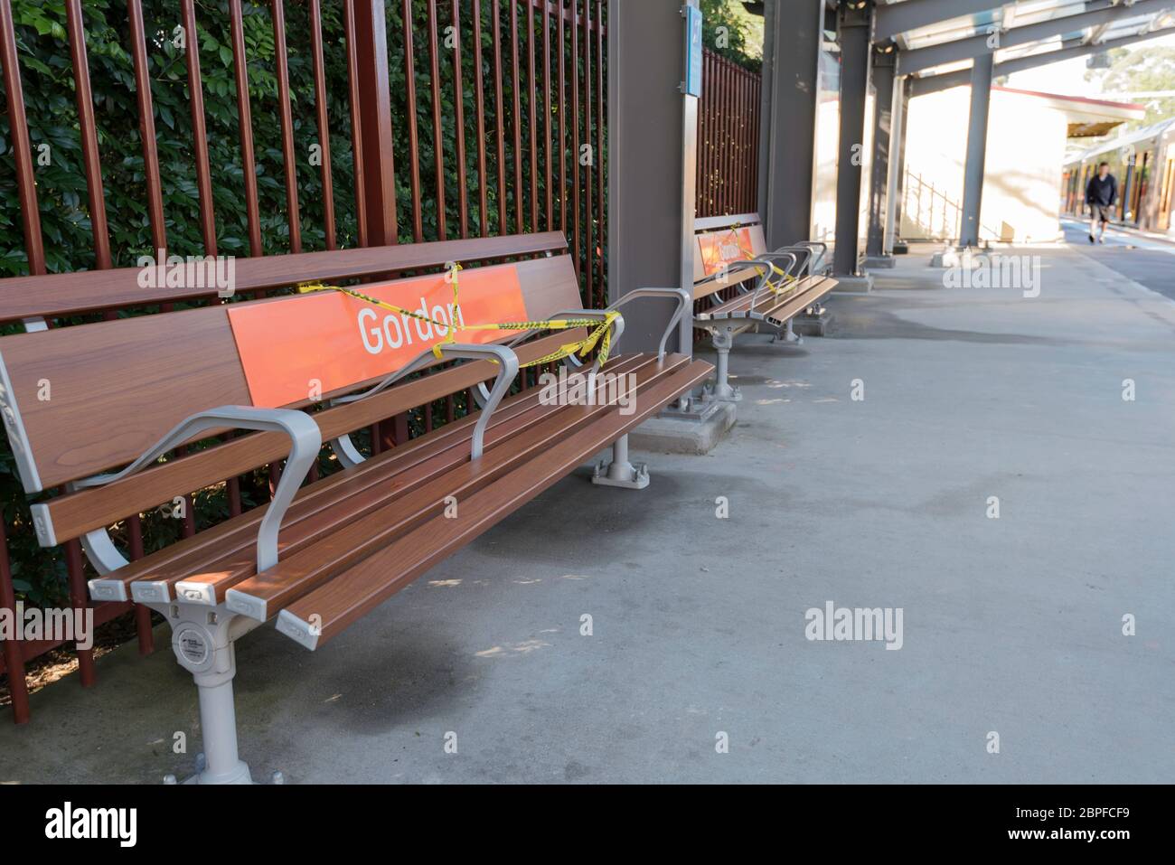 Posti a sedere su una piattaforma quasi vuota di una stazione ferroviaria A Sydney sono in parte registrati per mantenere la distanza sociale Durante l'epidemia di Covid-19 Foto Stock