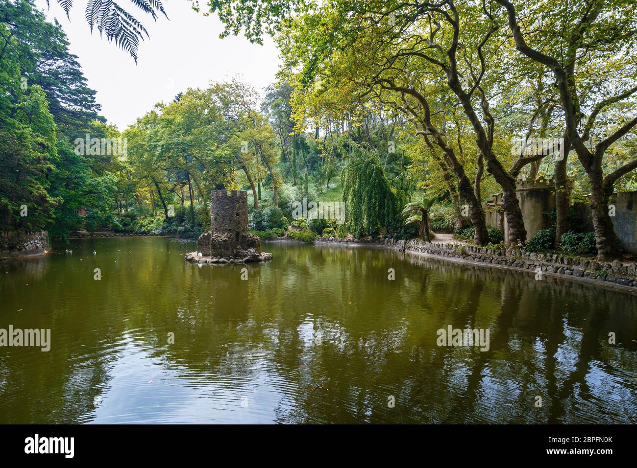 Old Duck House nel mezzo di uno stagno in un lussureggiante e verdeggiante parco naturale al pena Park a Sintra, Portogallo. Foto Stock