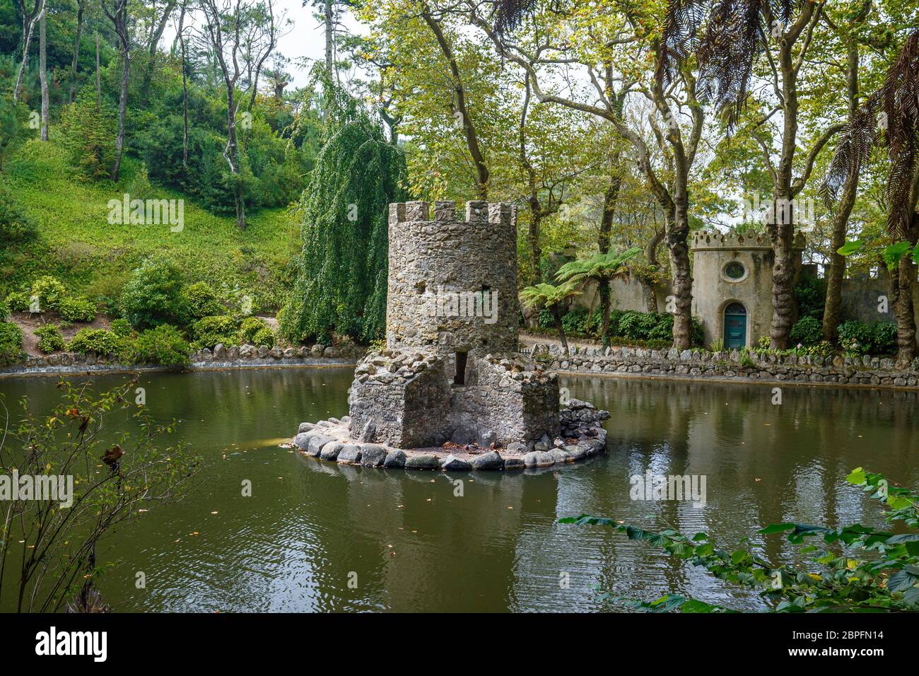 Old Duck House nel mezzo di uno stagno in un lussureggiante e verdeggiante parco naturale al pena Park a Sintra, Portogallo. Foto Stock
