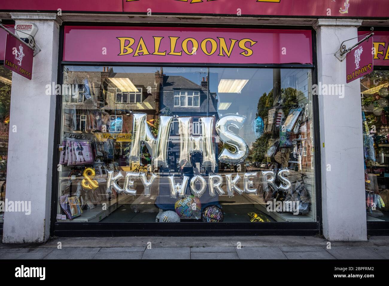 Party shop a East Sheen promozione NHS Key Workers durante il blocco del coronavirus con palloncini in vetrina, Southwest London, Inghilterra, Regno Unito Foto Stock