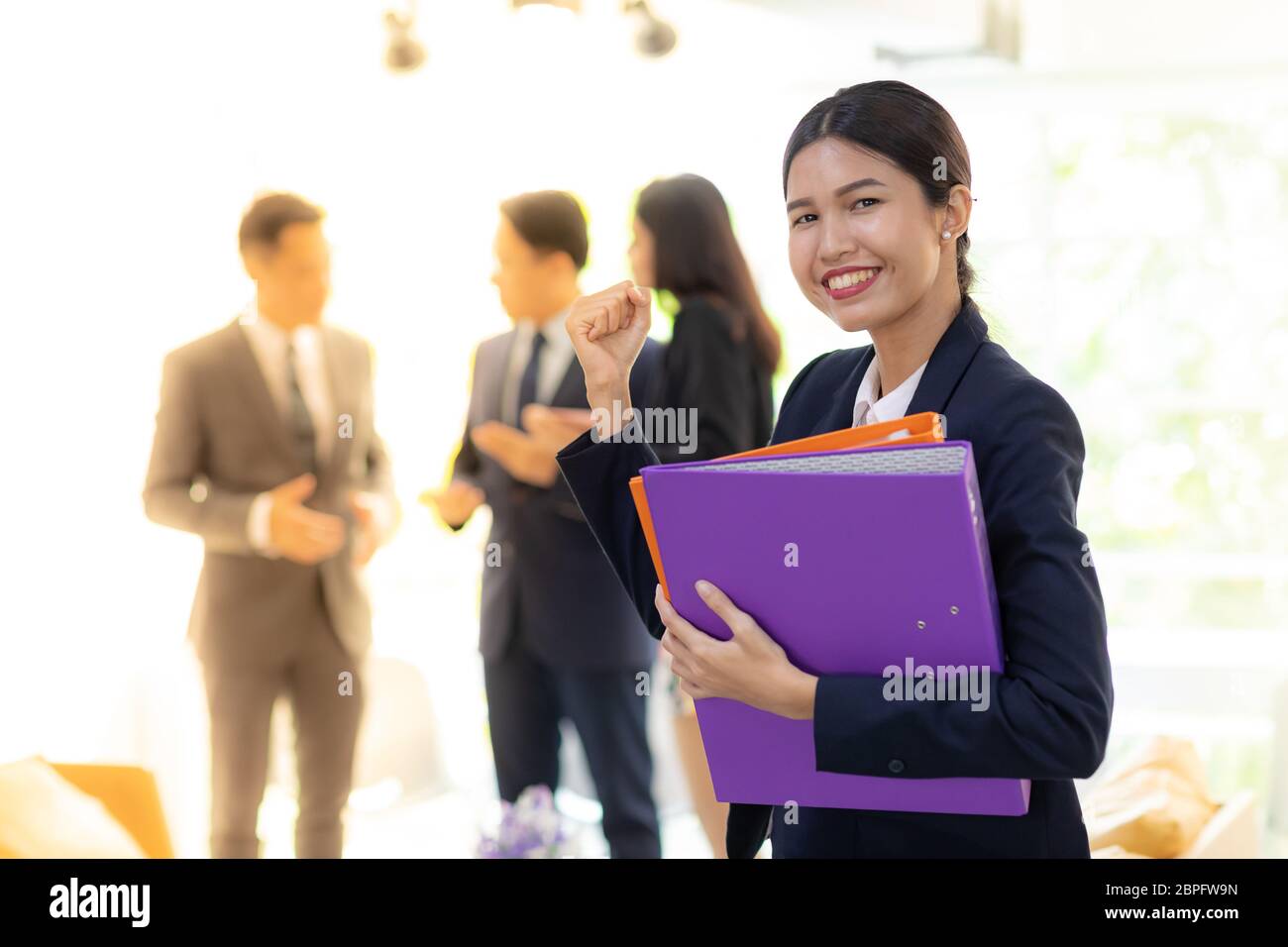 Ritratto di Asian imprenditrice tenere file di lavoro con il team aziende in background utilizzando per corporato lavori in background Foto Stock
