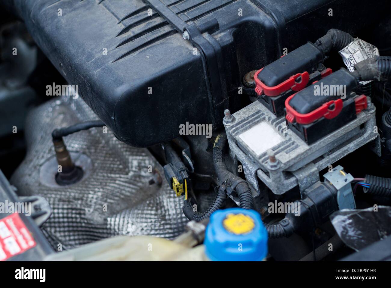 Vista del vano motore di una piccola vettura con accumulo di sporcizia e polvere sulla tec dell'alternatore diagnosi esperto in tecnologia del motore Foto Stock