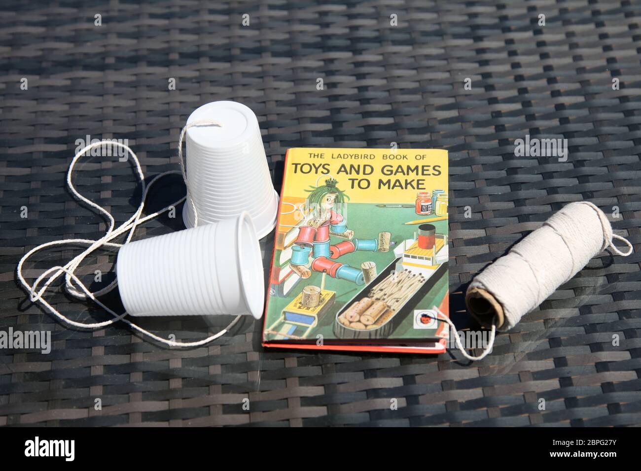 Ladybird libro di giocattoli e giochi - fare un telefono da coppe di plastica e corda, la scienza sperimentare con onde sonore e vibrazioni Foto Stock