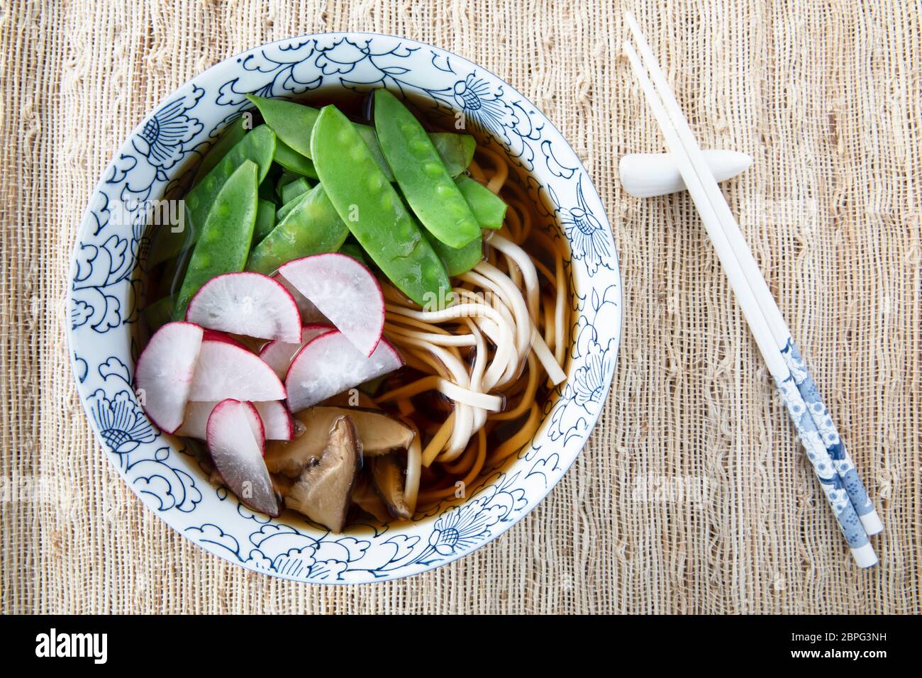 Riempire la coppa con udon noodle soup serie sei immagine: ciotola con tagliatelle, funghi shiitake, neve piselli, brodo e ravanelli. Foto Stock