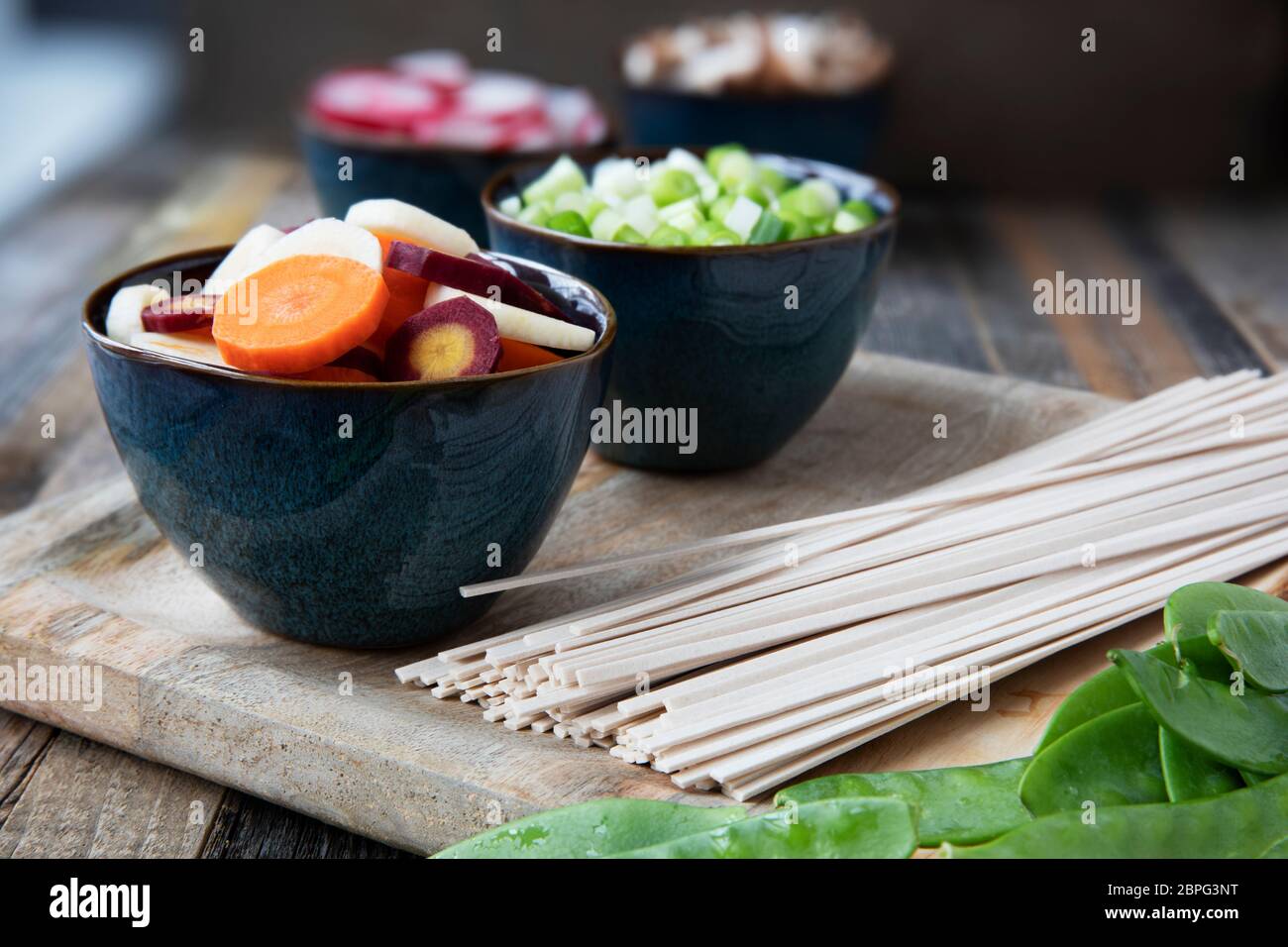 Carote, cipolline, udon tagliatelle e piselli neve pronto per preparare la zuppa. Foto Stock