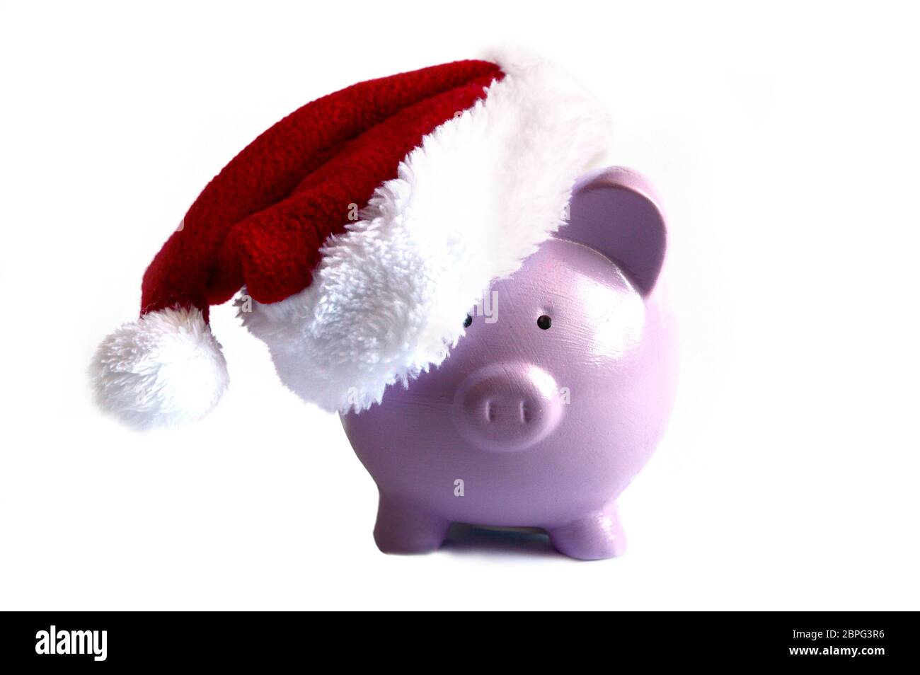 Una banca isolata di piggy che indossa un piccolo cappello di santa per i vari concetti di argomenti finanziari. Foto Stock