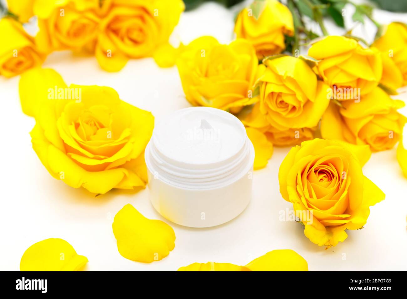 Botanico aromatico cosmetici. Dermocosmesi home trattamenti spa con petali gialli, bocciolo di rosa, naturale crema per il viso Foto Stock