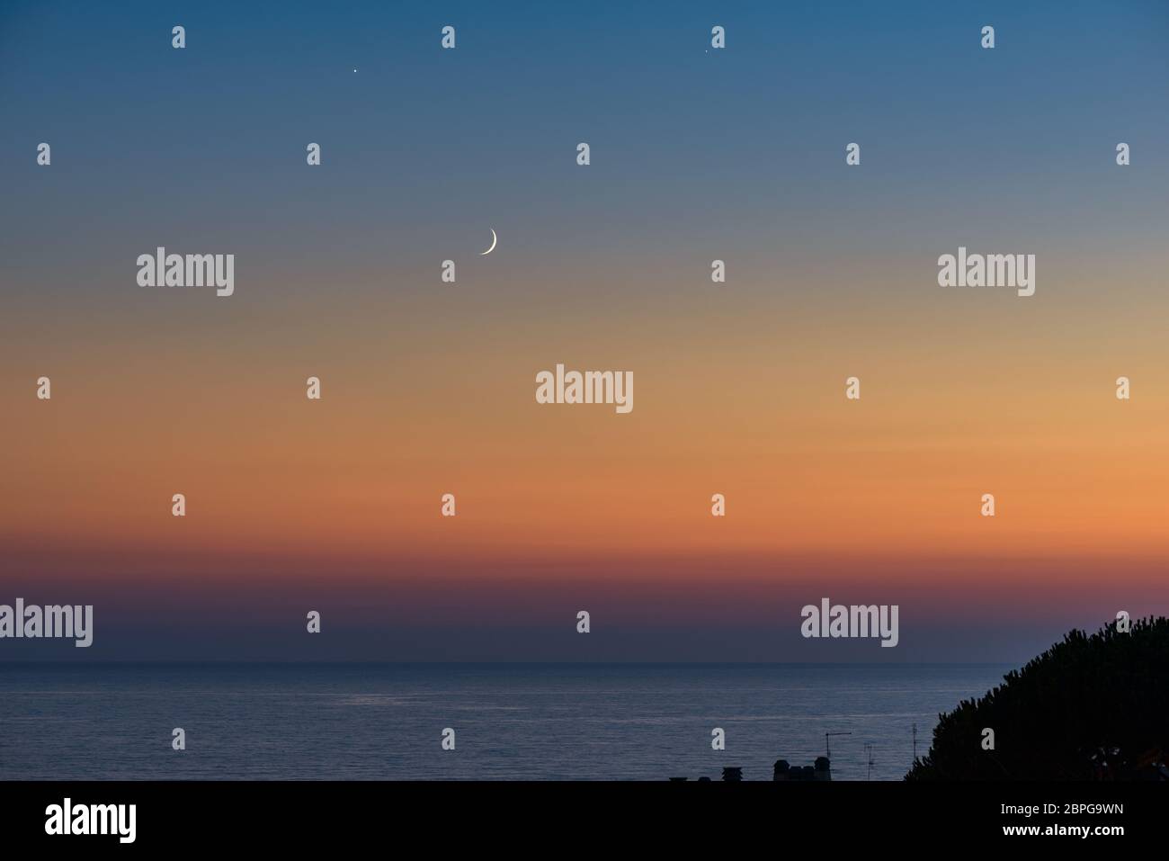 Riscaldare il tramonto in italia, con la luna e Venere sulla sinistra della luna Foto Stock