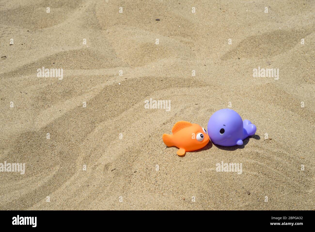 Divertente e colorato dei giocattoli di plastica sulla spiaggia Foto Stock