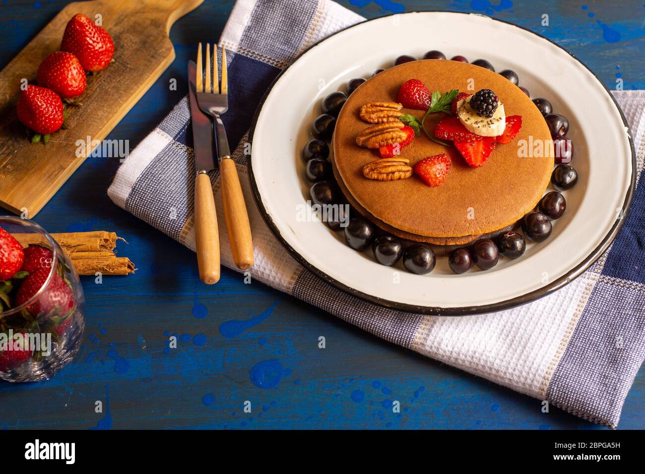 torte o pancake caldi con frutti rossi, fragole, more per colazione, vista dall'alto, orizzontale Foto Stock
