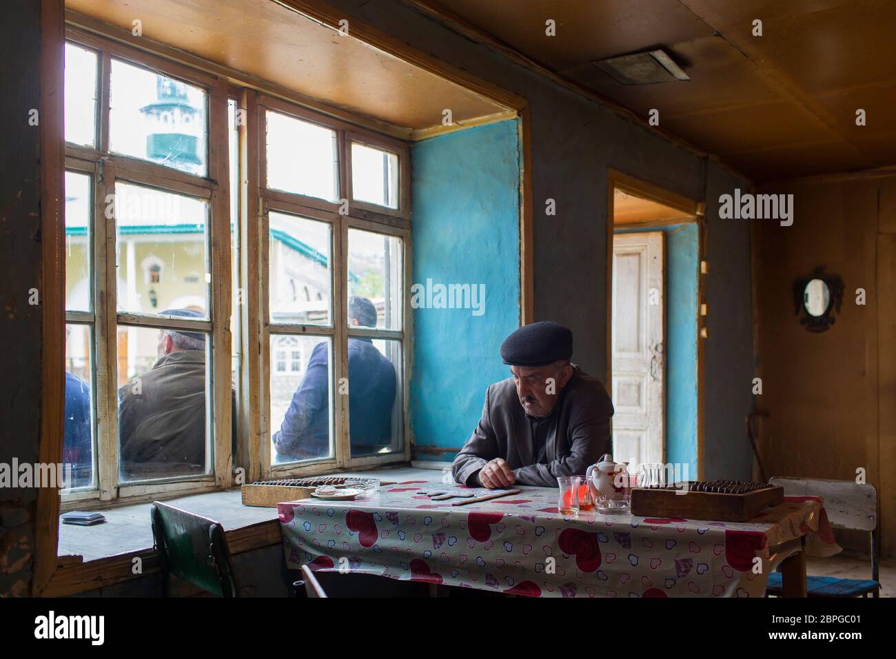 Gli uomini nel villaggio di Lahic si riuniscono nel negozio di tè per incontrare e giocare a dominos mentre beve tè e fumando sigarette in Azerbaigian Lahic. Foto Stock