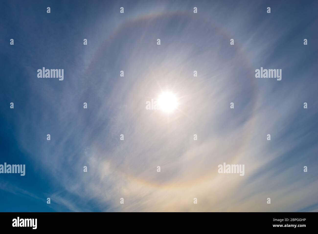 Alone intorno al sole. Cerchio luminoso e colorato a 22 gradi nel cielo. Foto Stock