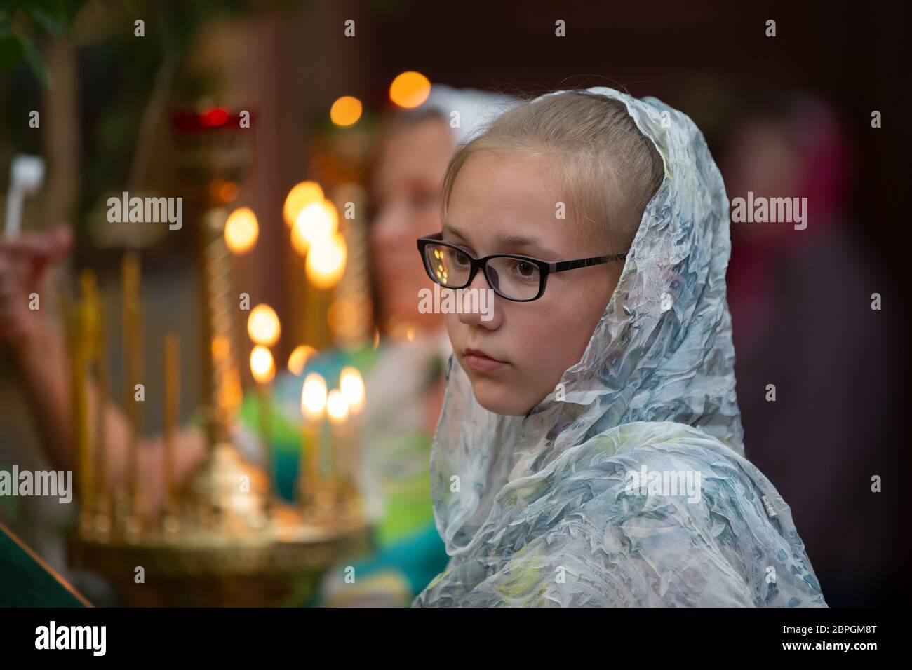 Ragazza adolescente in un velo in una chiesa. Foto Stock