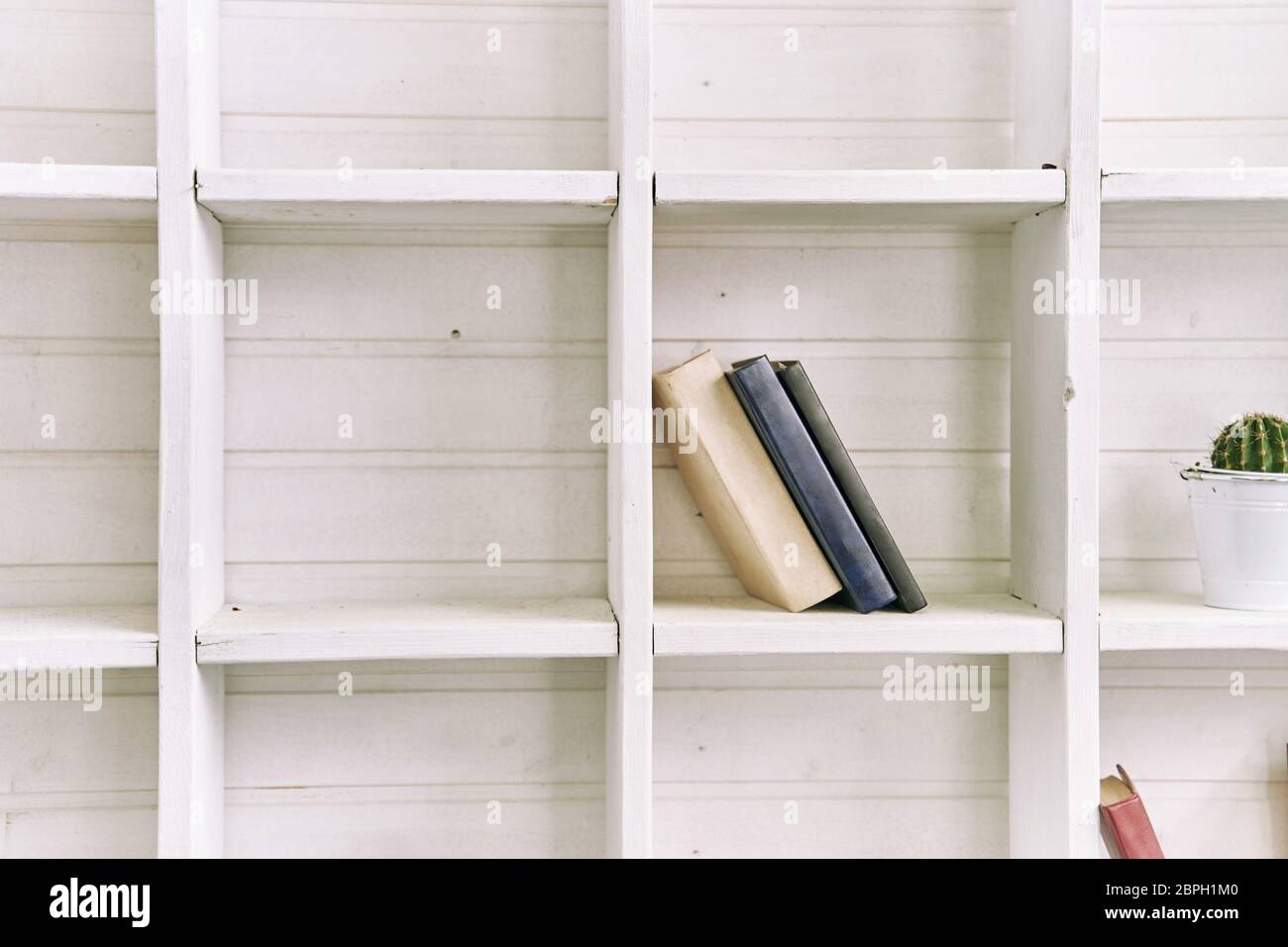 Ripiani in legno bianco con libri antichi. Libreria in legno. Foto Stock