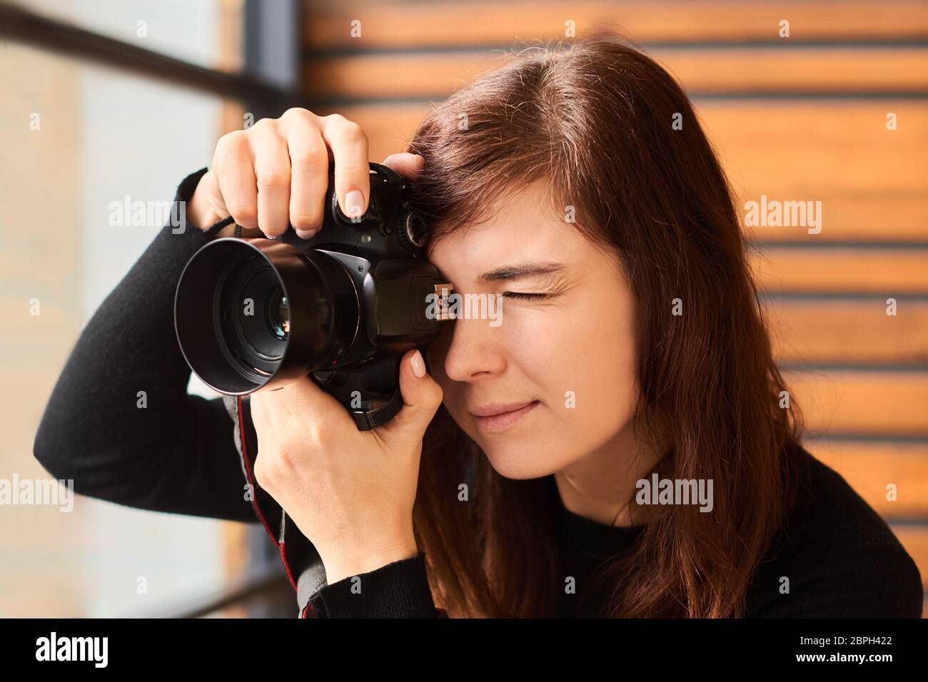 fotografo donna che scatta foto con la fotocamera su foto professionali con luce diurna Foto Stock