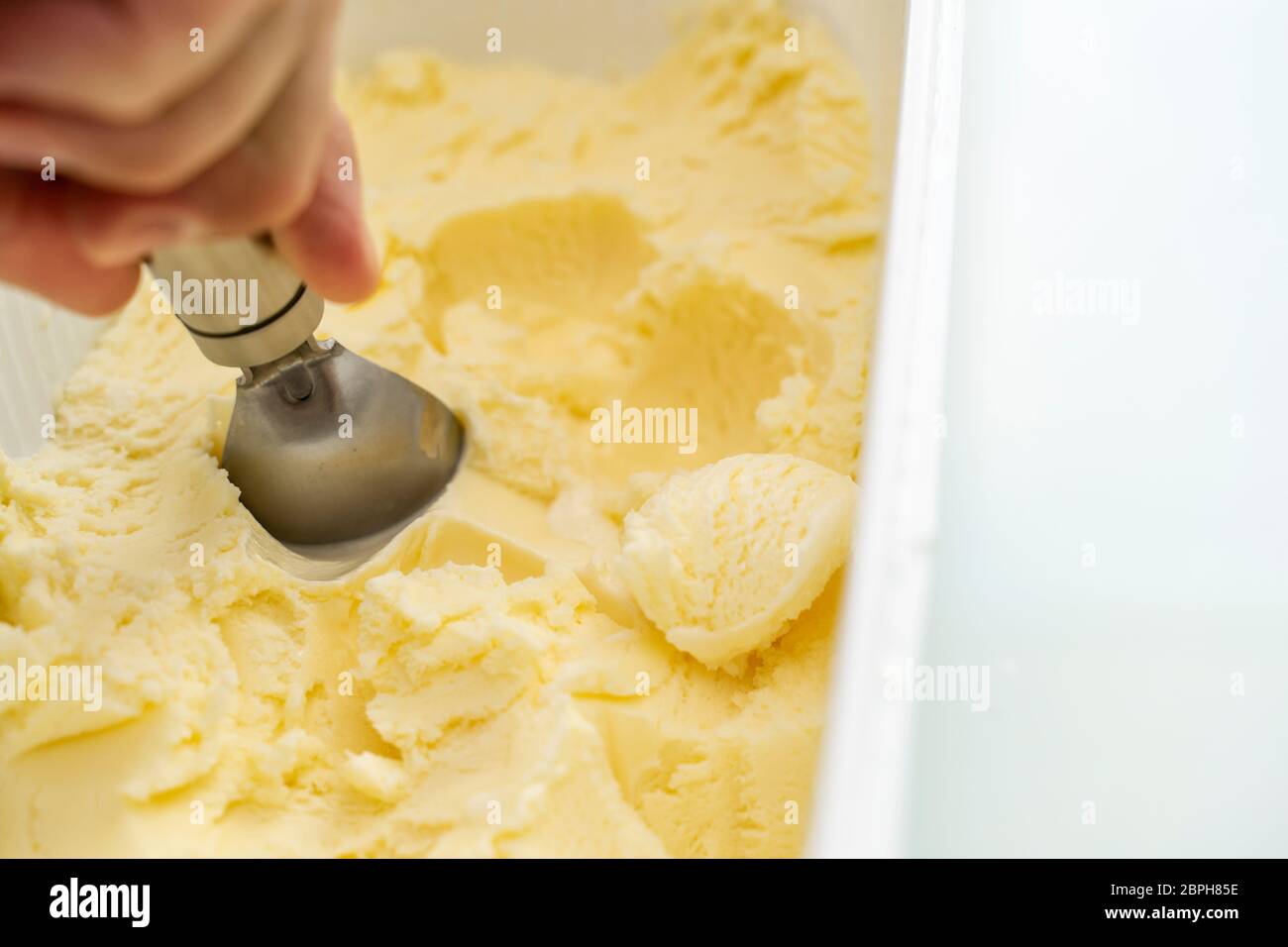 Gelato alla vaniglia. Un cucchiaio di gelato prende un po 'dalla confezione. La palla di gelato. Spazio per il testo. Foto Stock