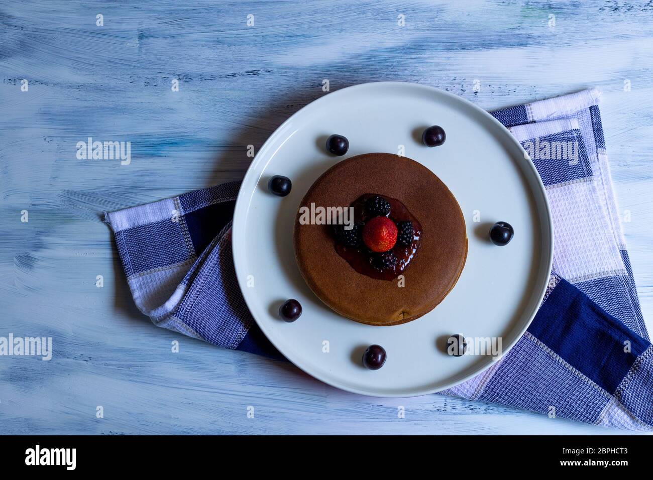 torte o pancake caldi con frutti rossi, fragole, more per colazione, vista dall'alto, orizzontale Foto Stock