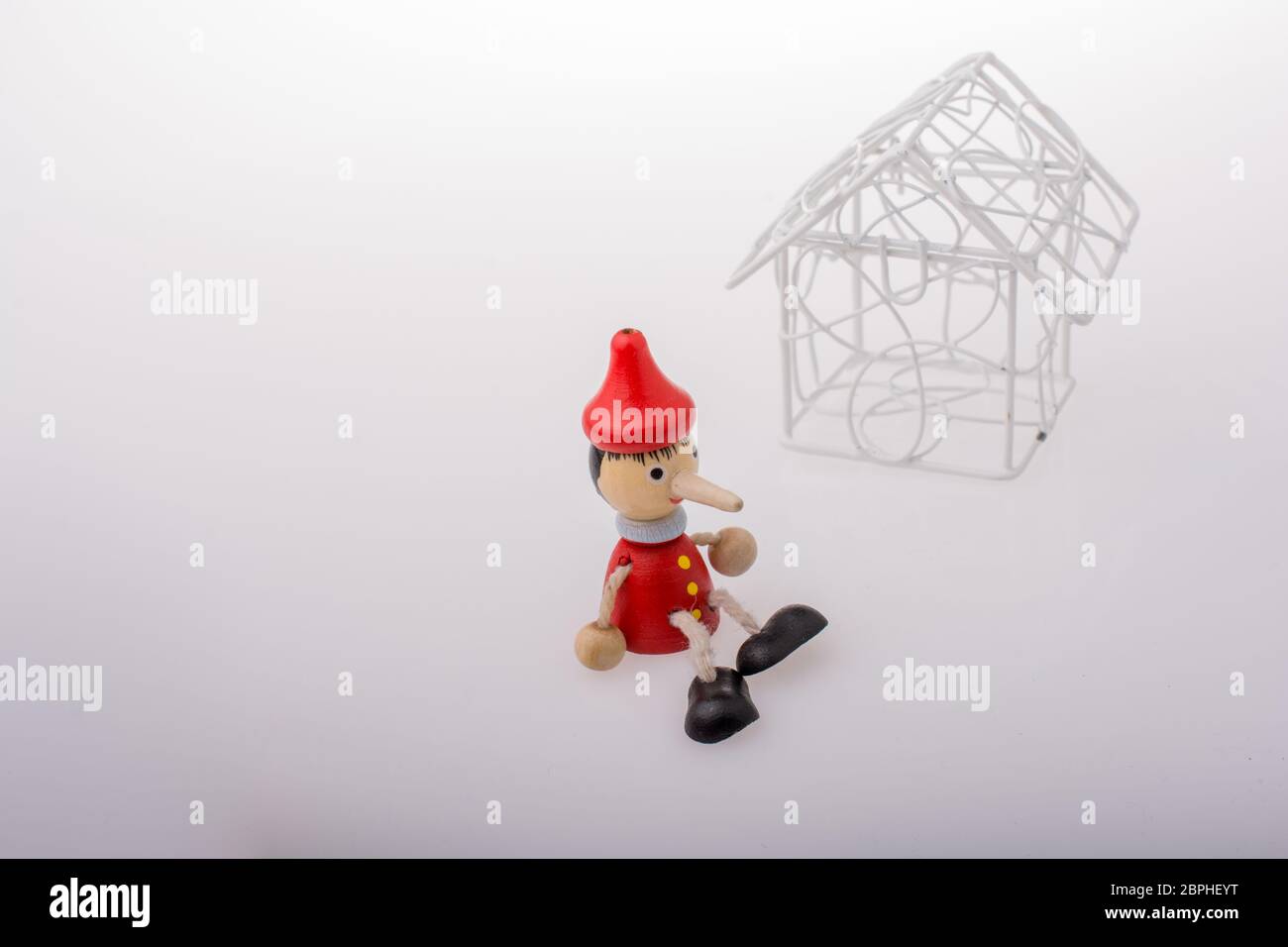 Pinocchio è seduto accanto a un modello di casa Foto Stock