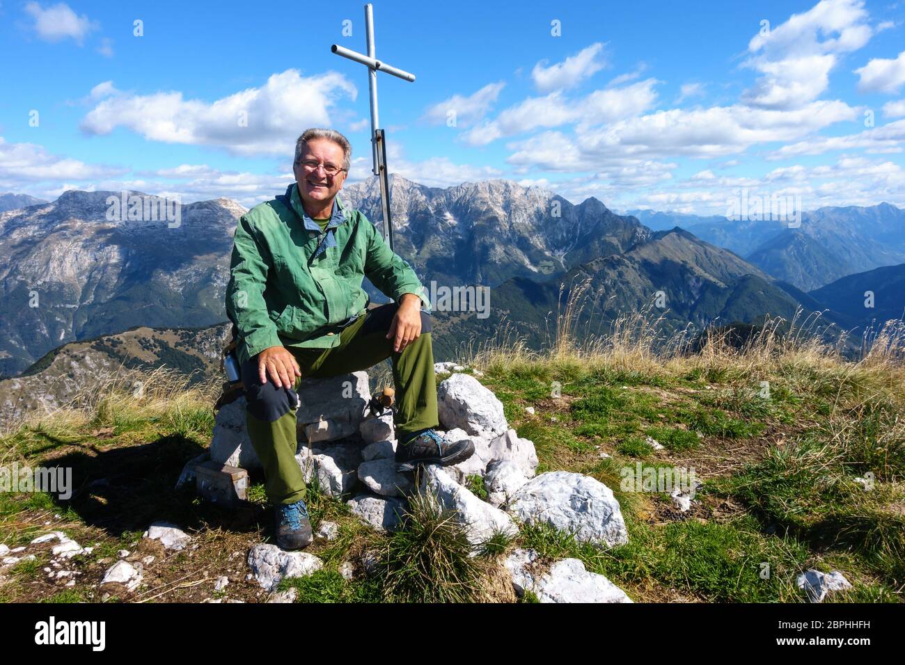 Coppia escursionista seduta sul picco e sorridente e guardando sulla fotocamera. Foto Stock