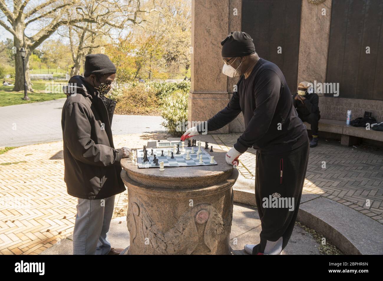 Gli uomini mascherati hanno una partita di Scacchi nel Prospect Park durante la pandemia del Covid-19 a Brooklyn, New York. Foto Stock