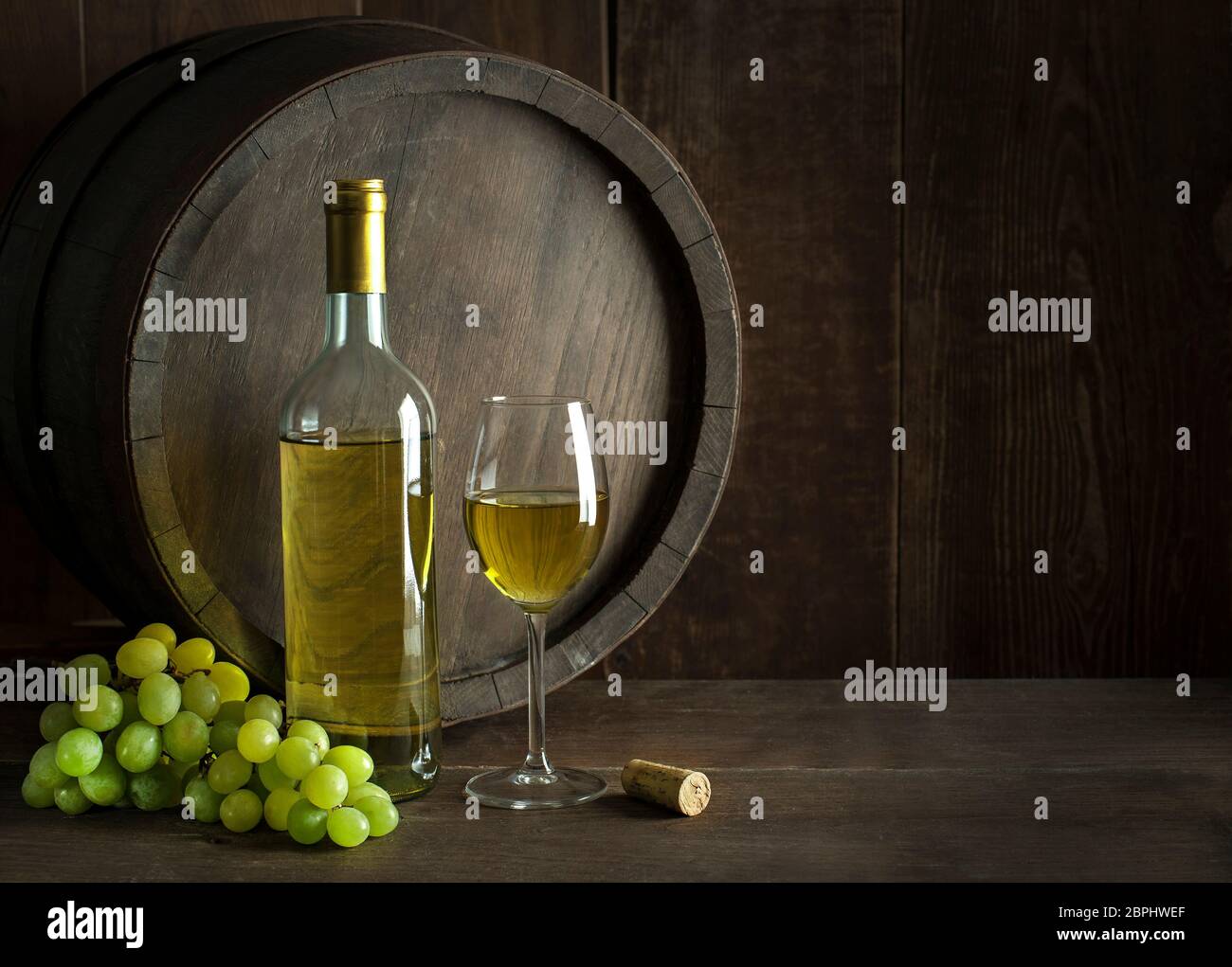 Bottiglia di vino bianco con un tappo di sughero. Bicchiere di vino con lo sfondo della camera Foto Stock