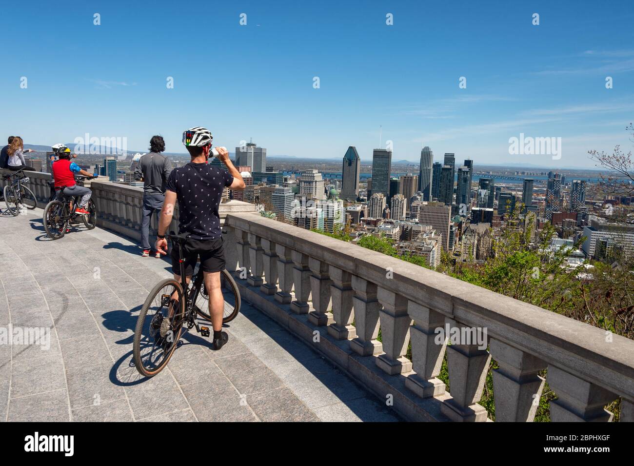 Montreal, CA - 18 maggio 2020: Turisti che guardano lo skyline di Montreal e che godono di una calda giornata di primavera al Belvedere Kondiaronk. Foto Stock