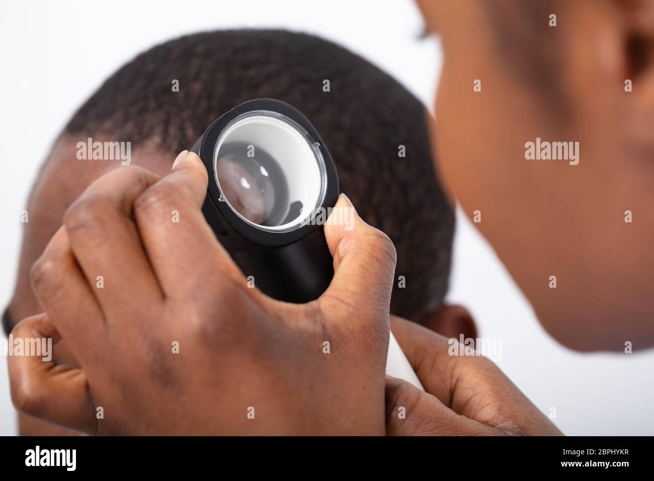 Giovane africano medico dell'uomo con capelli Dermatoscope su sfondo bianco Foto Stock