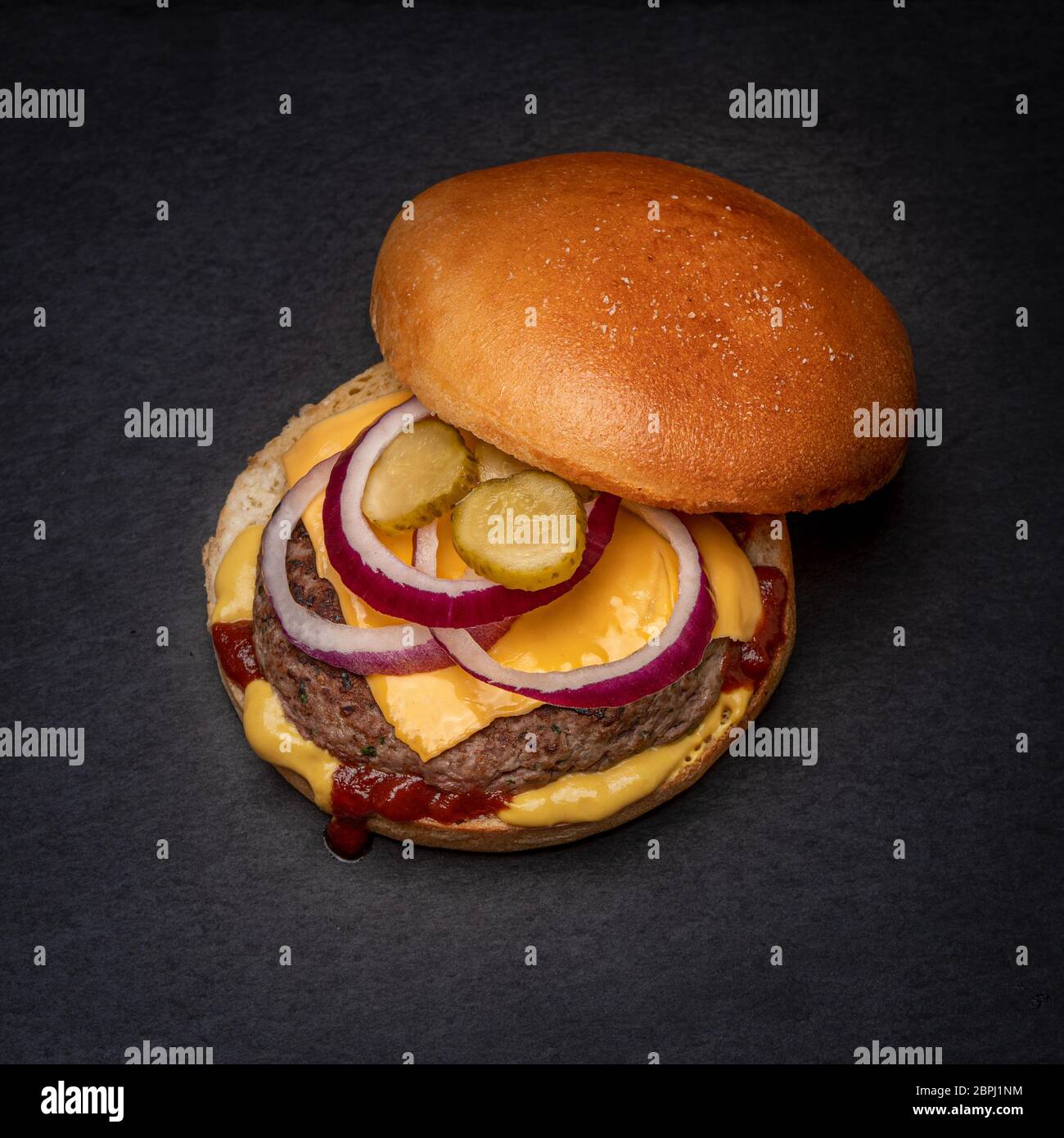 Hamburger di manzo al formaggio vista dall'alto su pietra nera Foto Stock