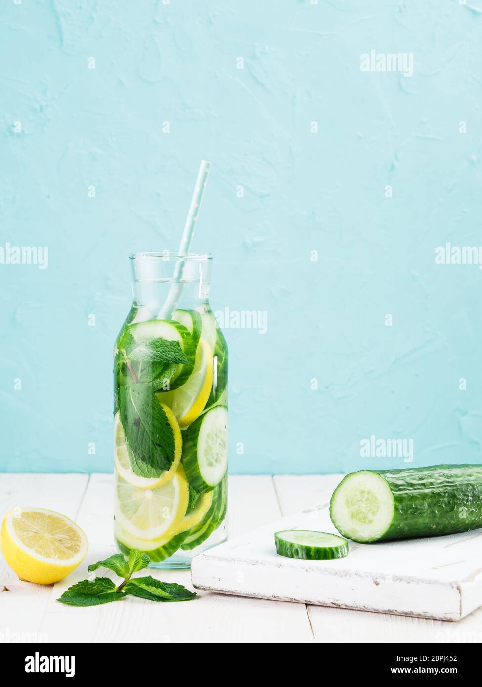 Infusa detox acqua con il cetriolo, limone e menta in una bottiglia di vetro sul tavolo bianco. La dieta, mangiare sano, la perdita di peso del concetto. Spazio di copia Foto Stock