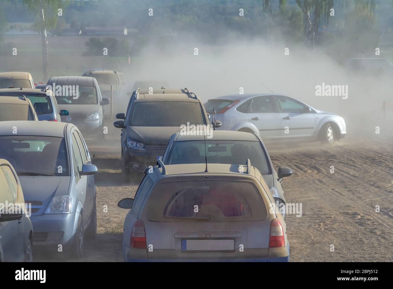 Parcheggio polveroso scenario dello spazio su un campo compreso un sacco di polvere auto coperti in serata nella Germania meridionale Foto Stock