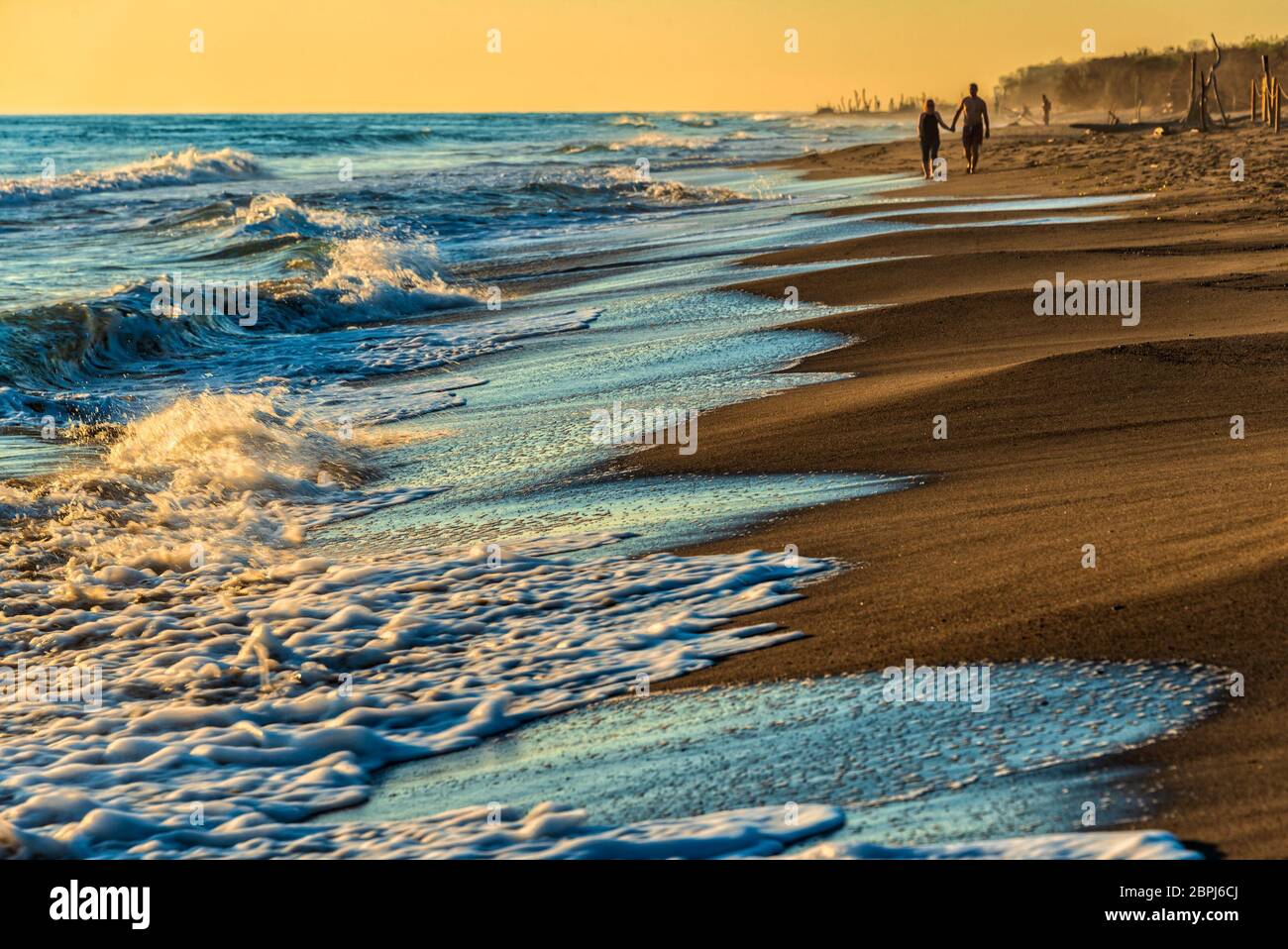 Una tranquilla passeggiata al tramonto sulla spiaggia di Alberese, vicino a Grosseto, Italia Foto Stock