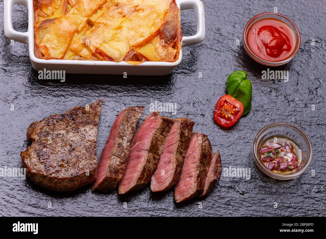 Bistecca in fette con patate gratinate Foto Stock