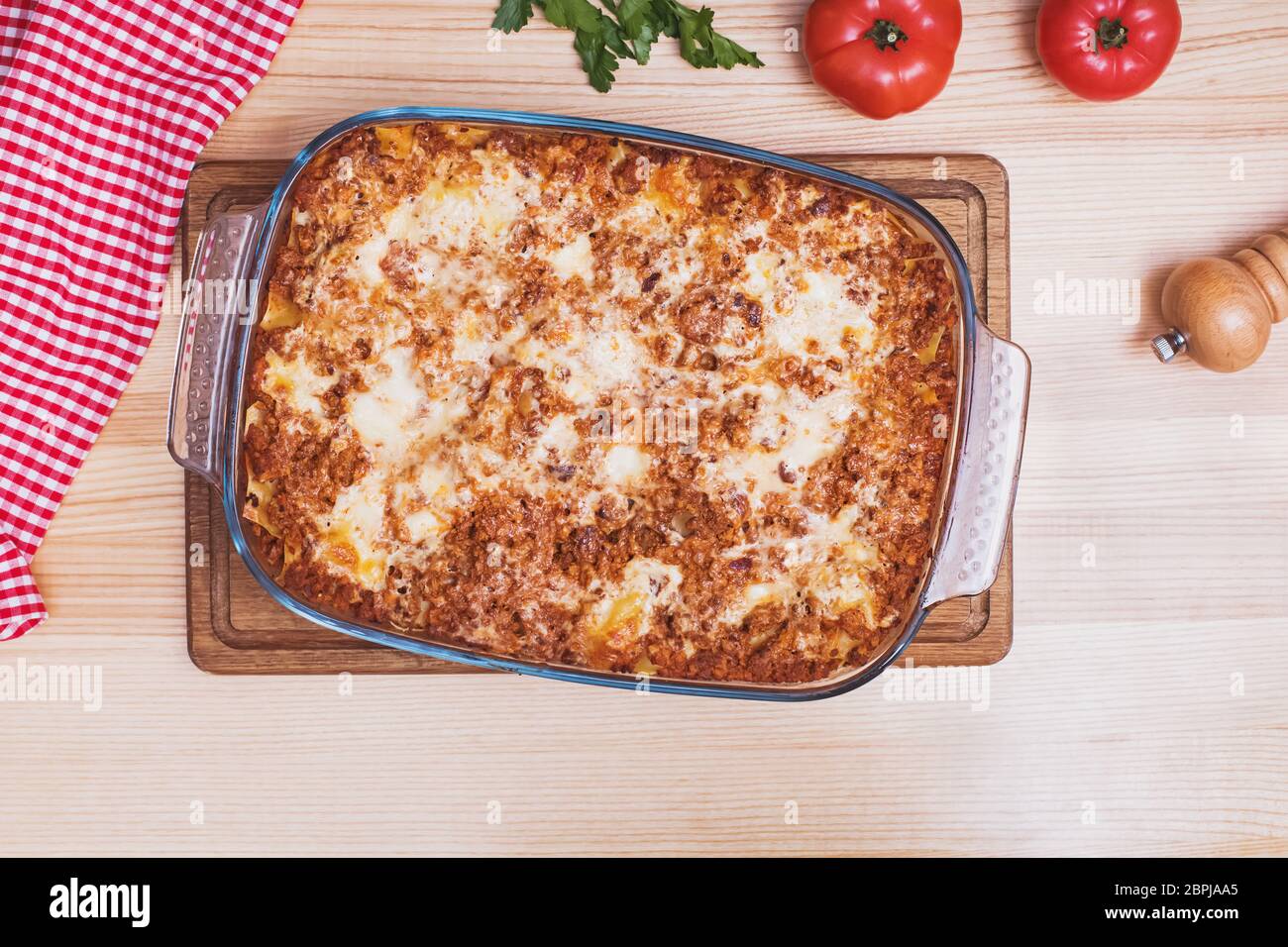 Deliziosa lasagna tradizionale italiana fatta con salsa bolognese di manzo tritato su tavolo di legno Foto Stock