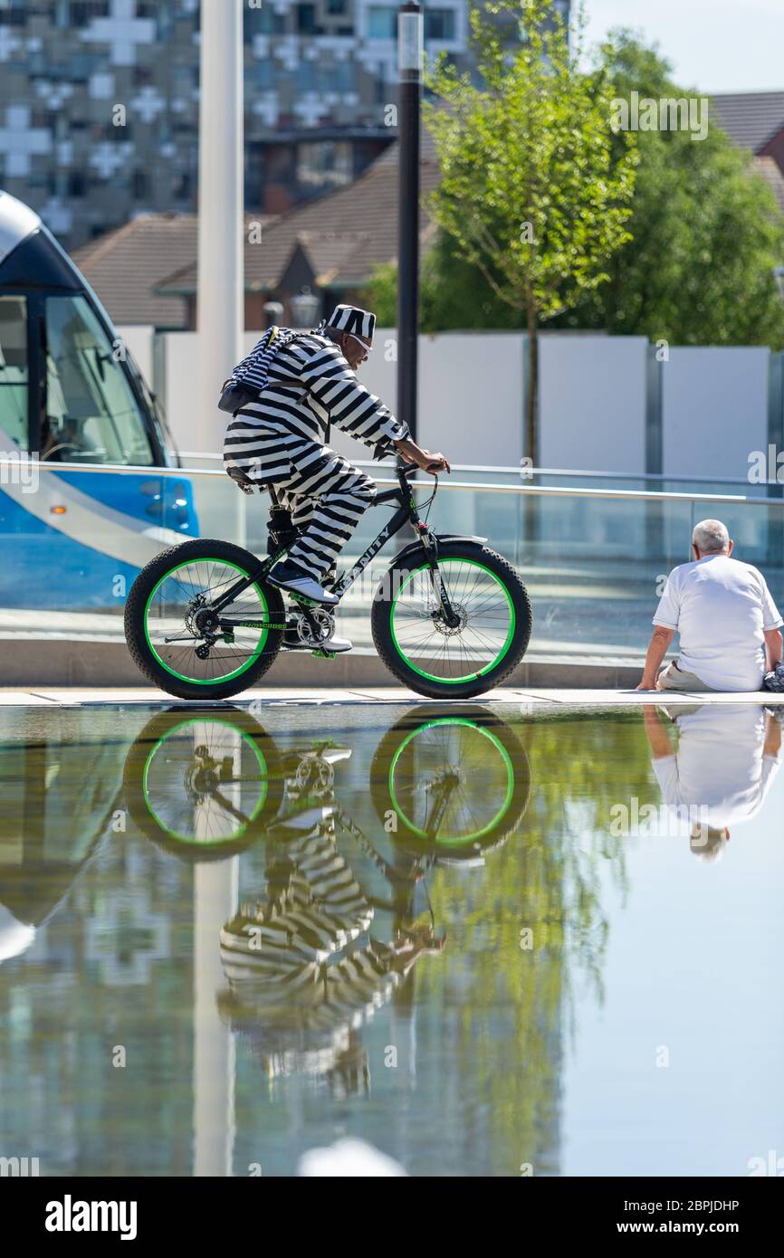 Birmingham, Regno Unito. 19 maggio 2020. Un ciclista elegantemente vestito ha un giro di esercizio intorno alle fontane in Centenary Square, nel centro della città di Birmingham. Credit: Peter Lopeman/Alamy Live News Foto Stock