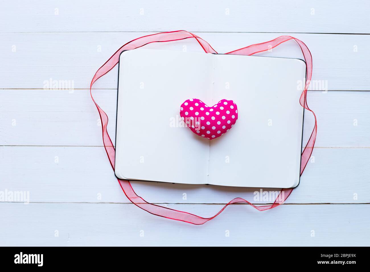 Diario notebook con san valentino cuori in bianco sullo sfondo di legno. Vista superiore Foto Stock