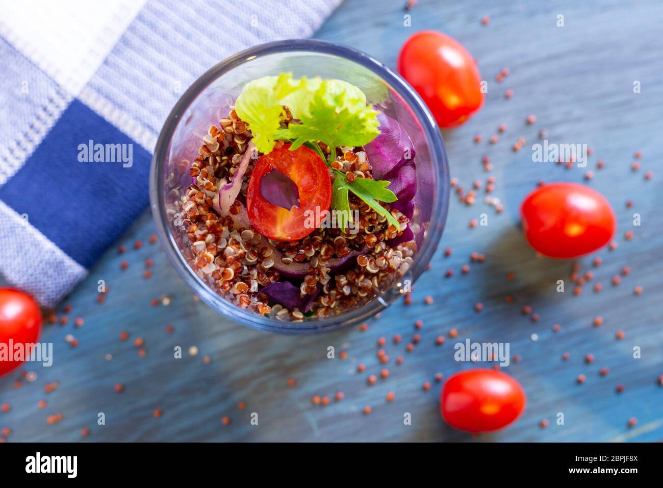 Insalata di quinoa rosse con pomodoro su un tavolo rustico. Concetto di cibo sano e supercibo. Foto Stock