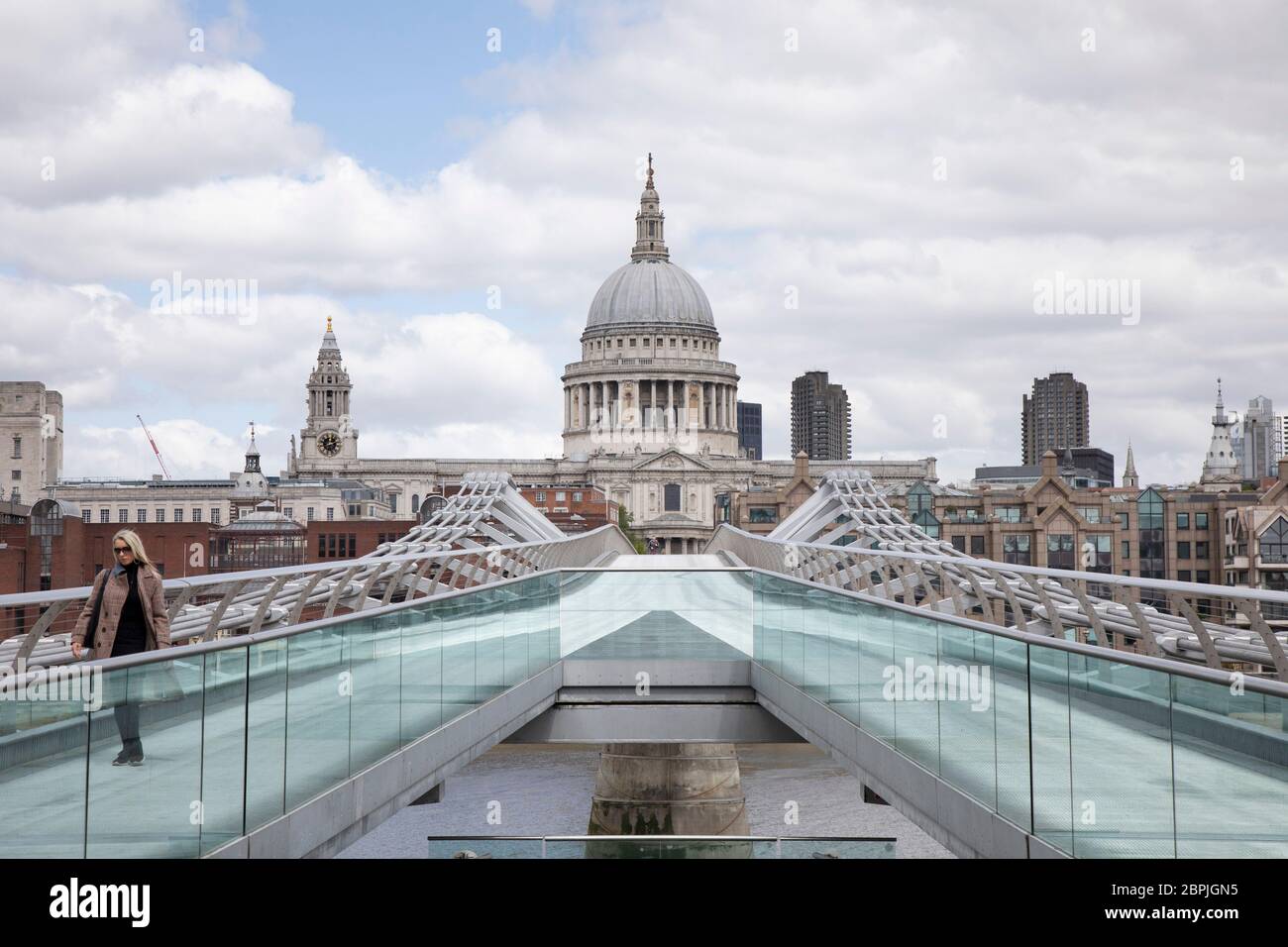 Vista che guarda attraverso Millennium Bridge verso la Cattedrale di St Pauls è molto tranquilla e silenziosa, a parte alcuni pedoni su strade vuote, mentre la chiusura continua e la gente osserva il messaggio soggiorno a casa nella capitale l'11 maggio 2020 a Londra, Inghilterra, Regno Unito. Il coronavirus o Covid-19 è una nuova malattia respiratoria che non è stata precedentemente osservata negli esseri umani. Mentre gran parte dell’Europa è stata messa in blocco, il governo britannico ha annunciato ora un leggero allentamento delle regole severe come parte della loro strategia a lungo termine, e in particolare l’allontanamento sociale. Foto Stock