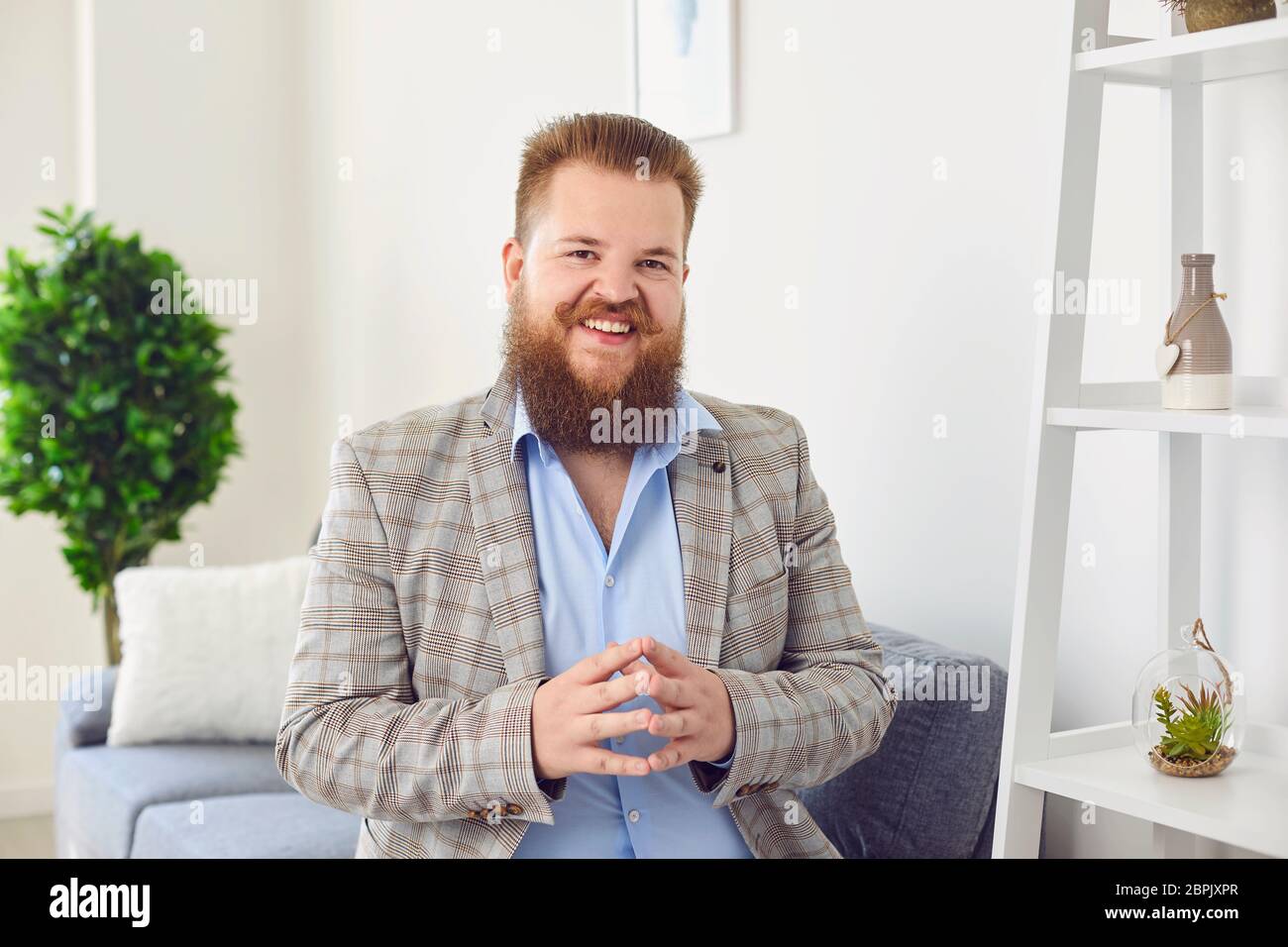 Persone online che guardano la fotocamera. Un uomo sorridente bearded che guarda la video video chat web call online accoglie sventolando la mano a casa. Foto Stock