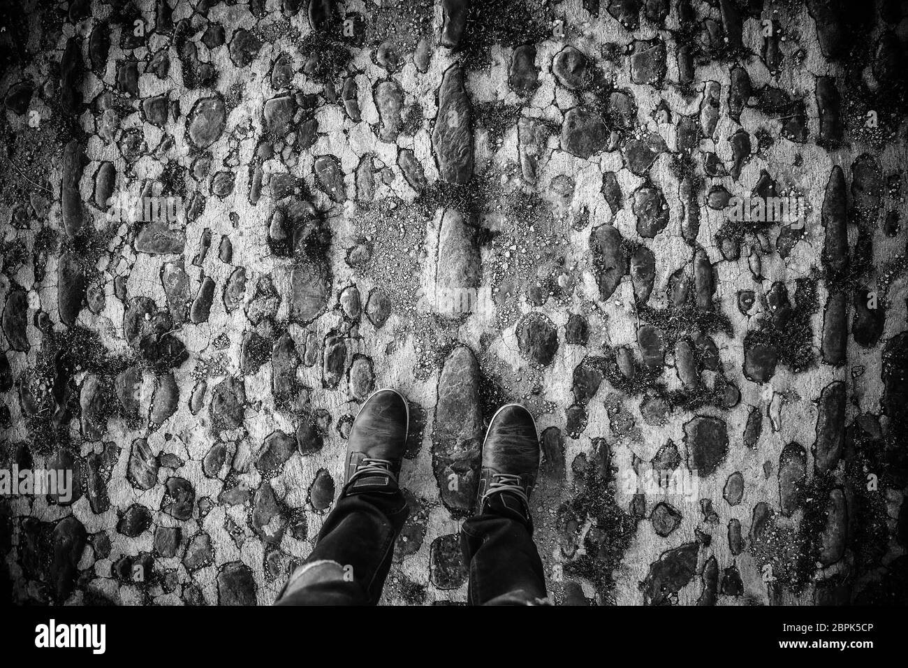 Piedi con stivali sulla strada, dettaglio delle moderne calzature, freddo in inverno Foto Stock