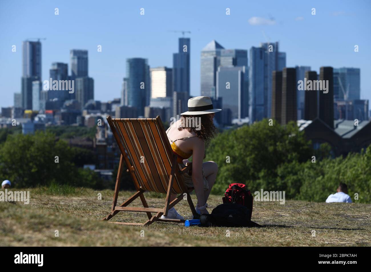 Una donna si sdraia su una sedia a sdraio e gode del caldo a Greenwich Park, Londra, dopo l'introduzione di misure per portare il paese fuori dalla serratura. Foto Stock