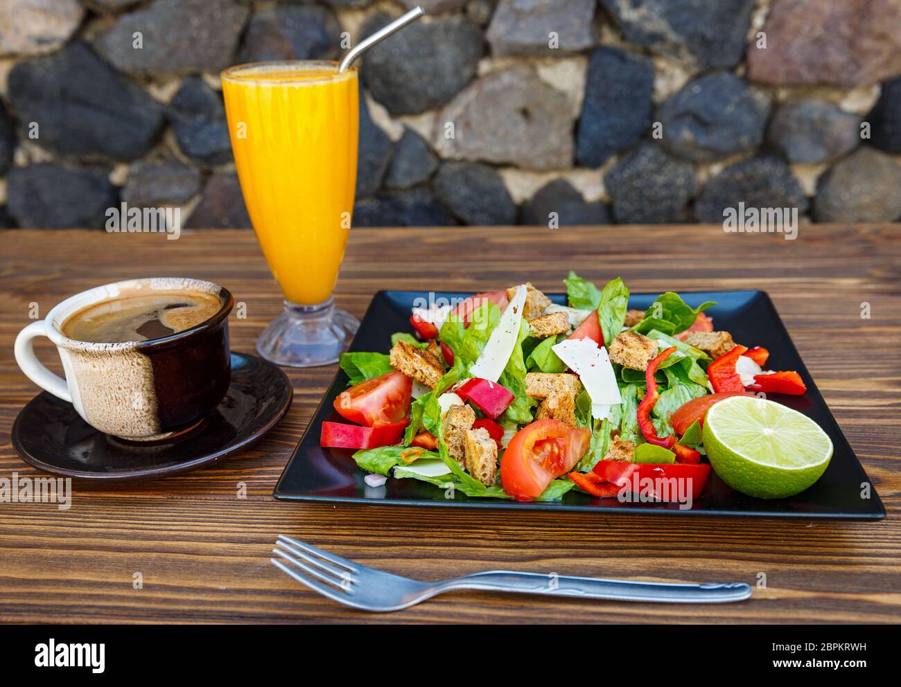 Insalata con salmone e verdure e bevande su un tavolo di legno Foto Stock