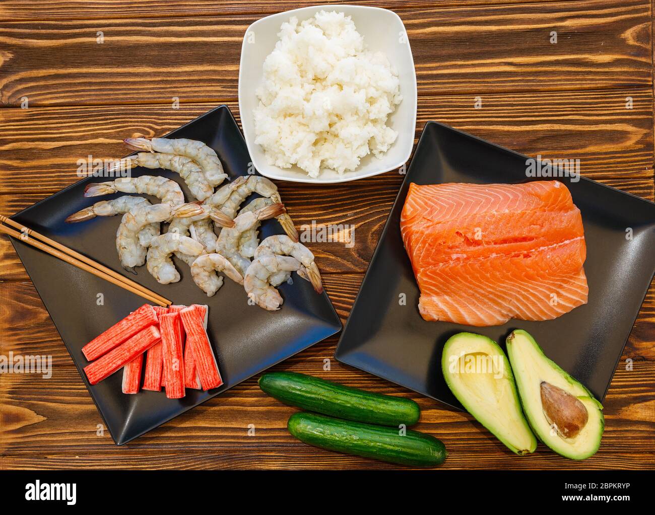 Frutti di mare e ingredienti per la preparazione di sushi su sfondo di legno Foto Stock