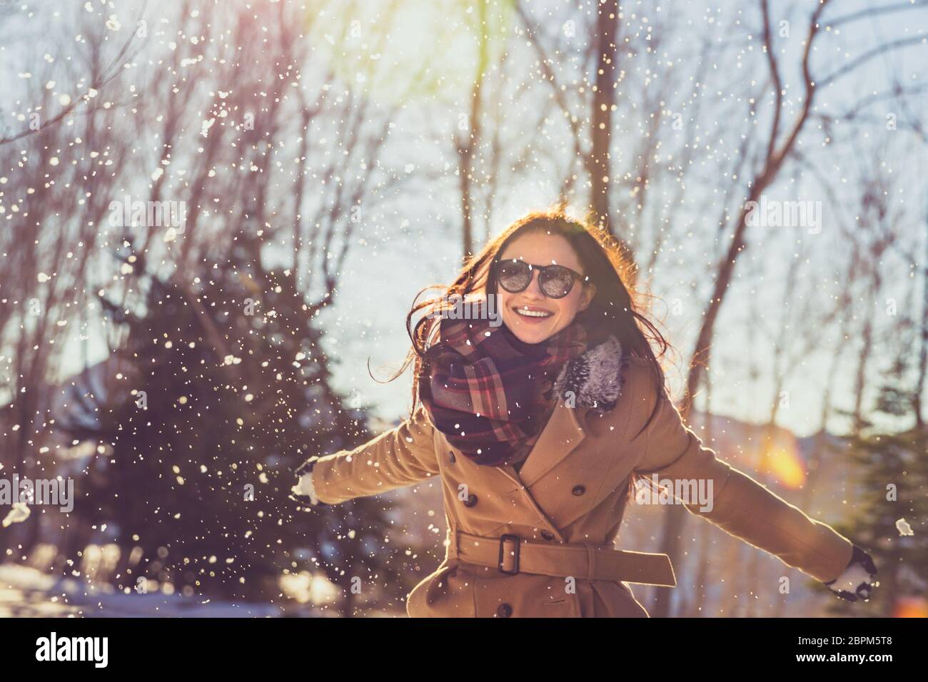 Ritratto di una bella ragazza con il piacere di trascorrere del tempo sulla luminosa giornata di sole in inverno park, divertirsi come un bambino felice vacanza invernale Foto Stock
