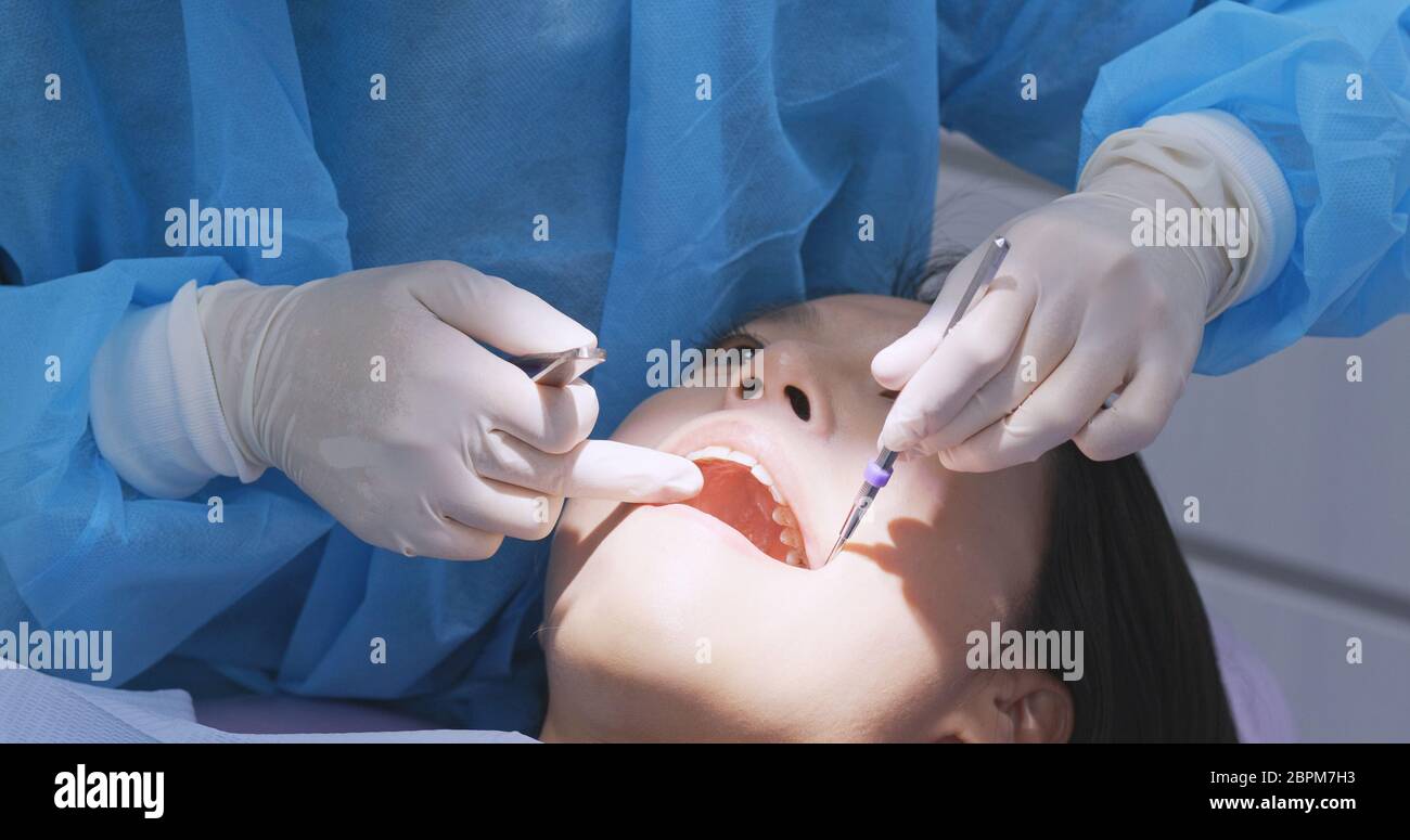 Paziente che controlla i denti con specchio presso la clinica dentale Foto Stock