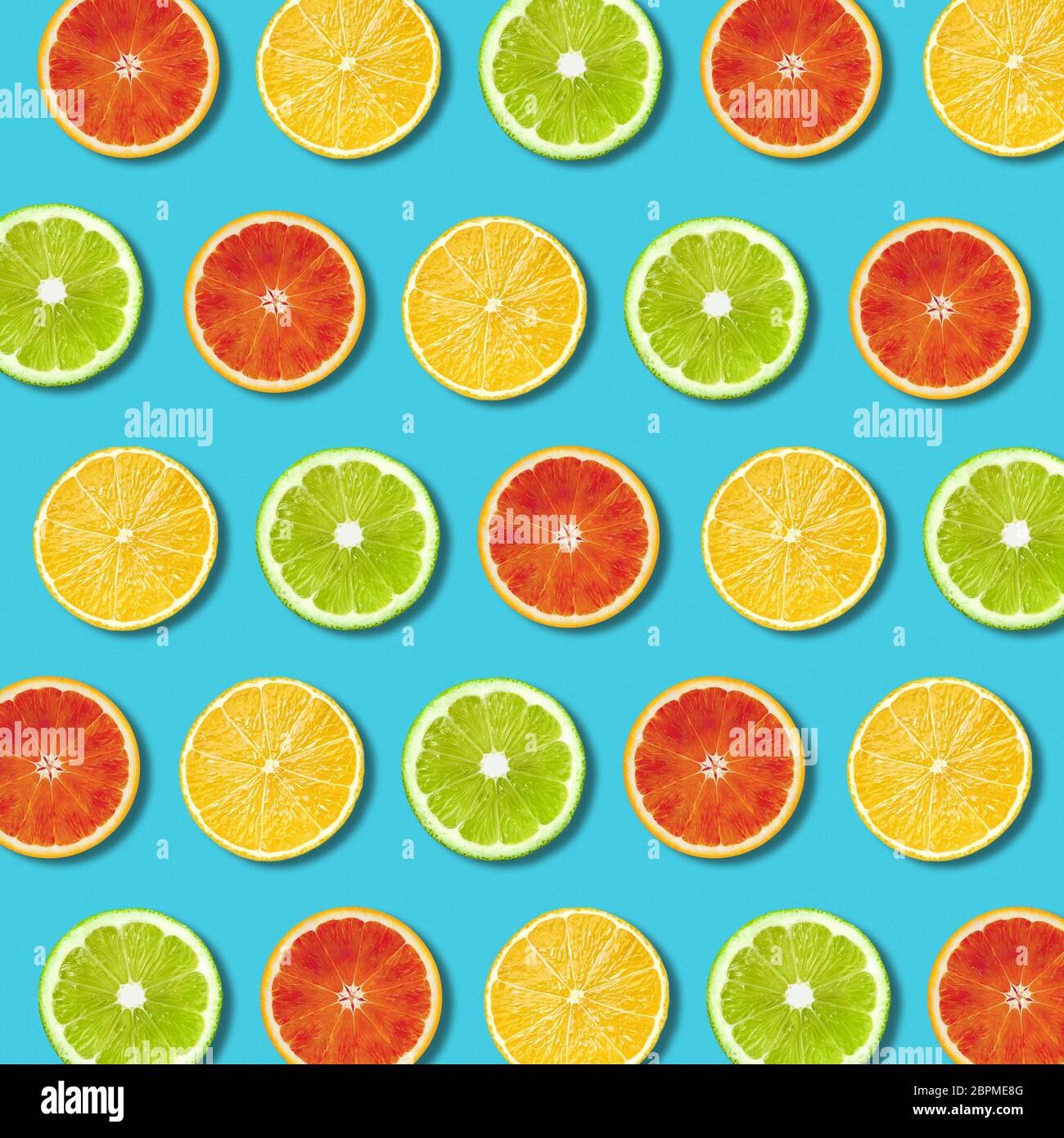 Multicolore limone vibranti, verde lime e rosso fette orande pattern su sfondo turchese. Minima laici flat top view food texture Foto Stock