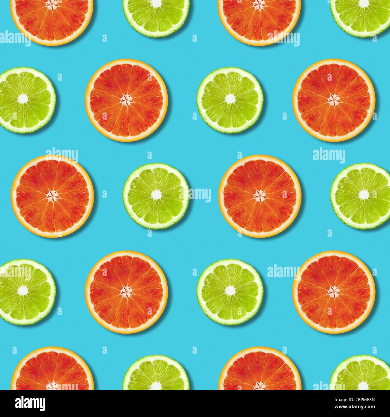 Vivace rosso arancio e verde lime fette di limone pattern sul colore turchese sfondo. Minima laici flat top view food texture Foto Stock