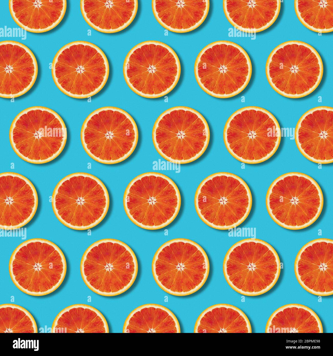 Red fettine di arancio modello sulla vibrante colore turchese sfondo. Minima laici flat top view food texture Foto Stock
