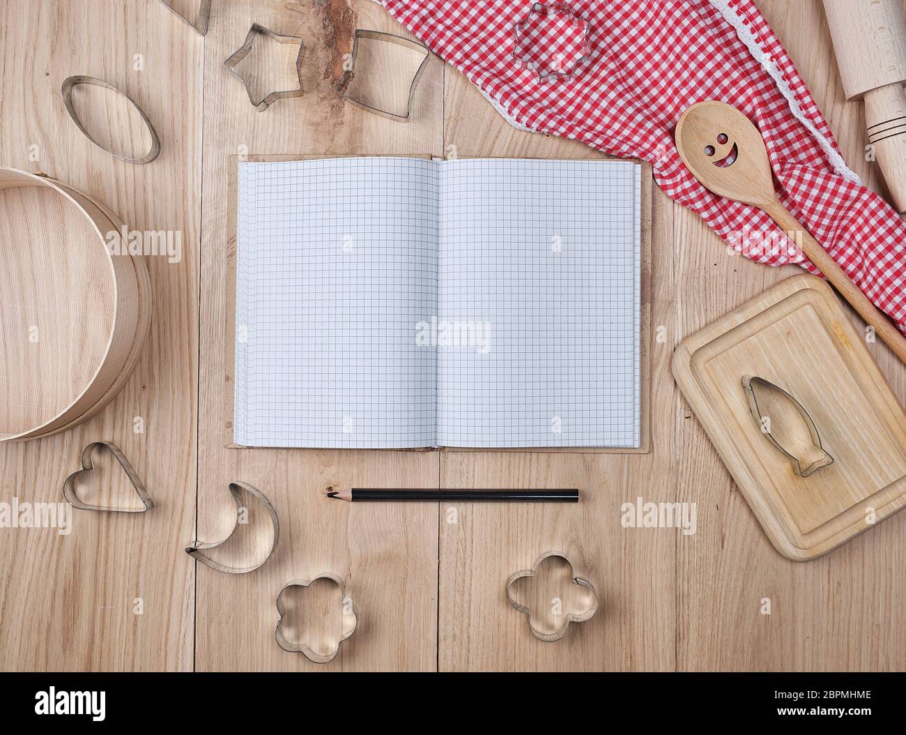 Vuoto notebook aperti in linea e cucina in legno accessori, concetto di ricetta Foto Stock